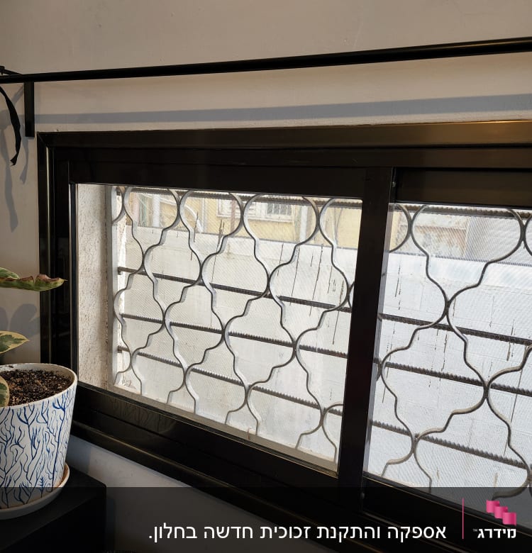 חלון זכוכית עם סורג מתכת דקורטיבי